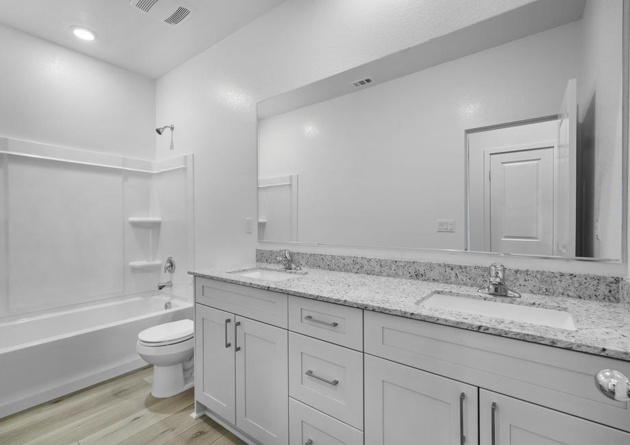 The secondary bathroom has a dual sink vanity and a tub/shower combo.