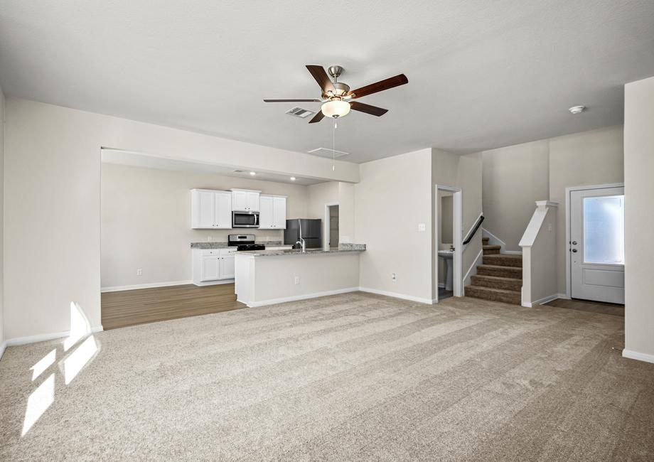 A spacious family room with carpet flooring.