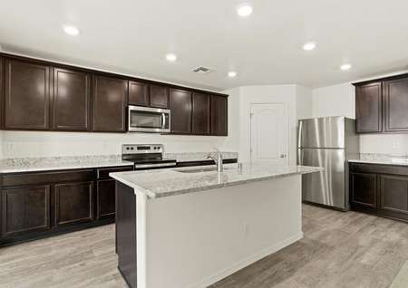 Kitchen with energy-efficient appliances, wood cabinets and sprawling granite countertops.