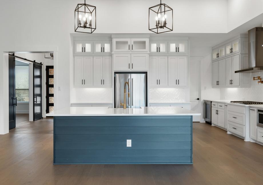 The kitchen has a beautiful blue island with quartz countertops.