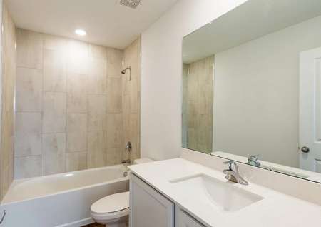 The guest bathroom has a beautifully tiled bathtub