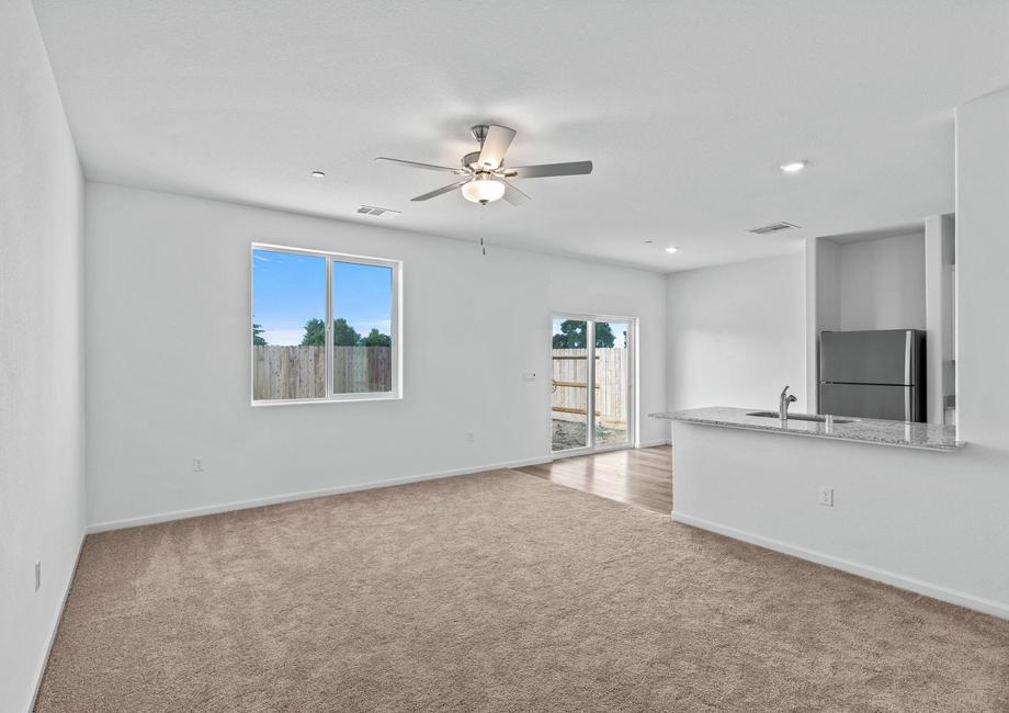 The family room is spacious with a ceiling fan and is open to the dining room.