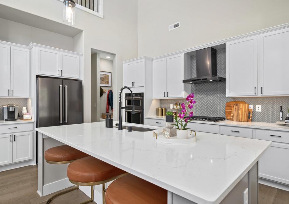 The kitchen highlights quartz countertops and black stainless steel appliances.