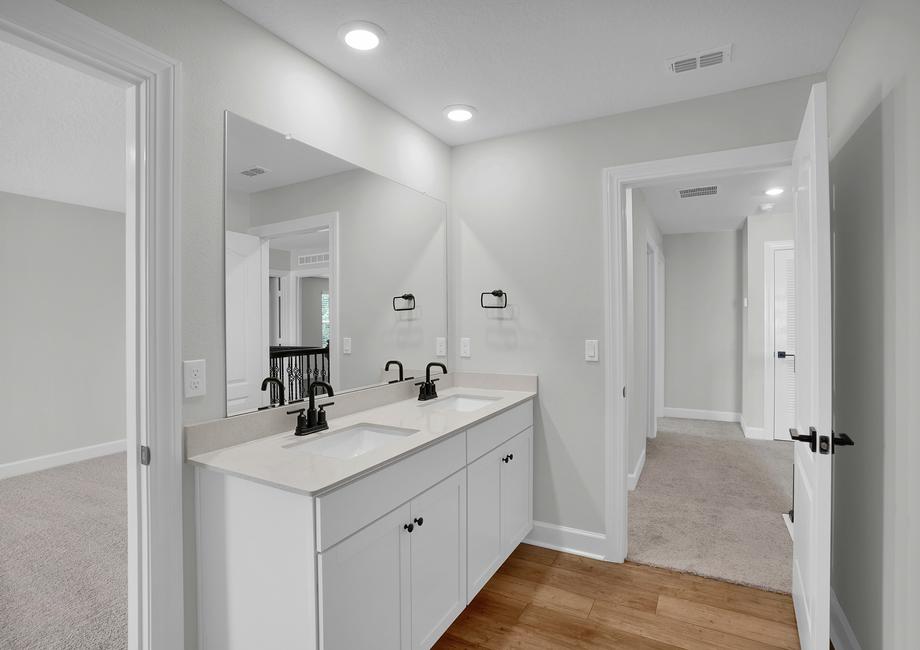 The second bathroom has a large double sink vanity and a sectioned off bathroom with a toilet