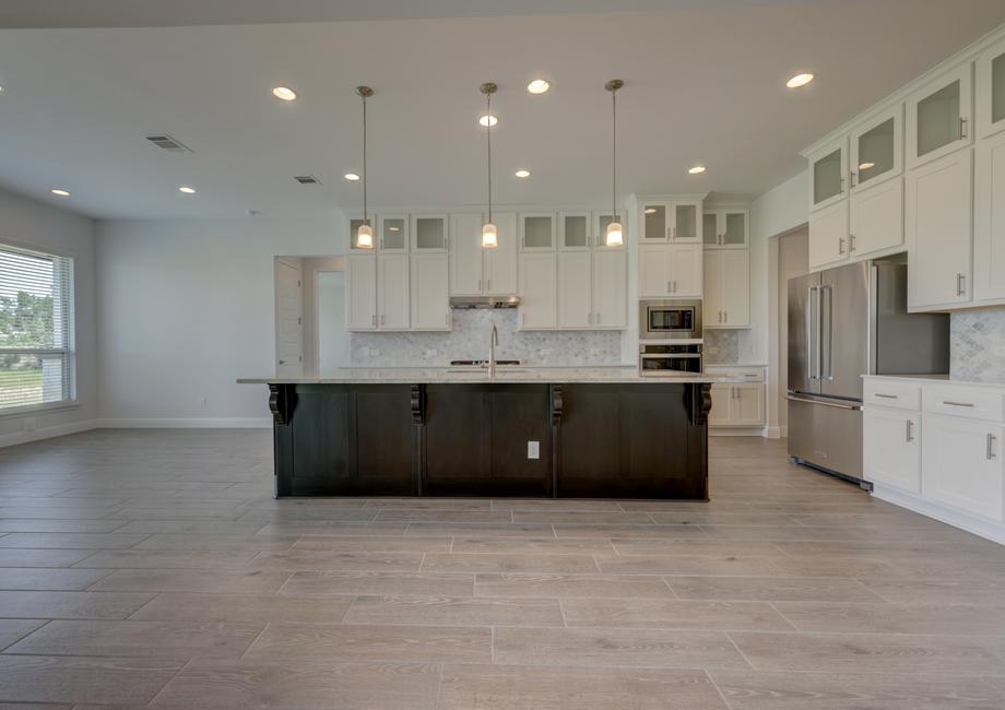 Fully-equipped kitchen with designer finishes, including oversized cabinetry, a large island, and stainless appliances.