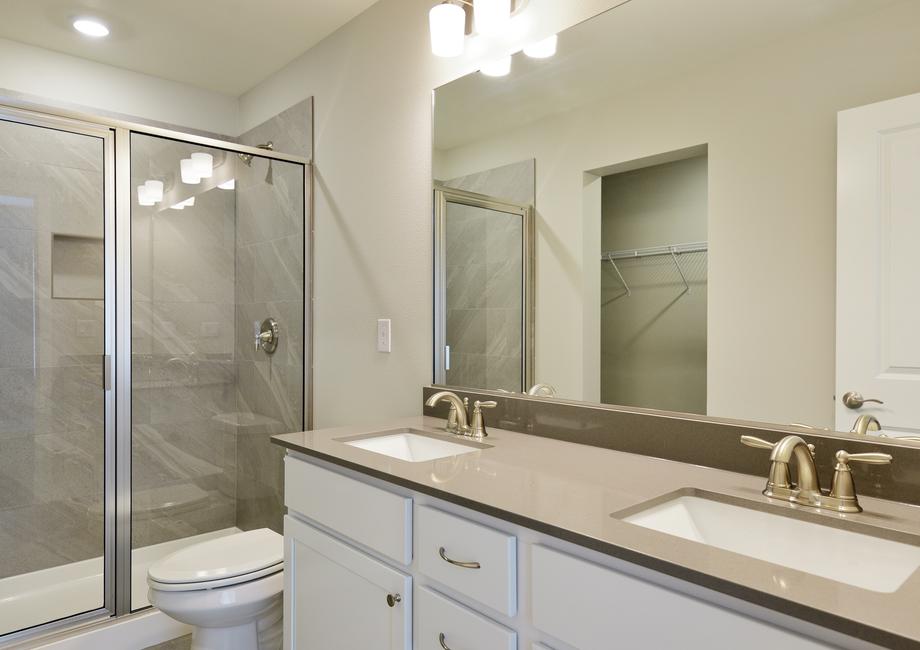 The master bathroom has a dual sink vanity and a step in shower.