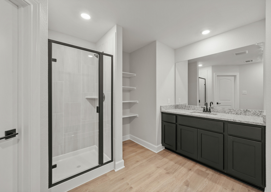 The master bathroom has a spacious vanity and a glass, walk-in shower.