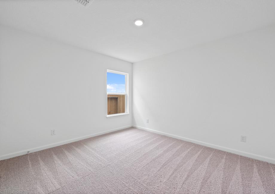 Secondary bedroom with tan carpet and recessed lighting.