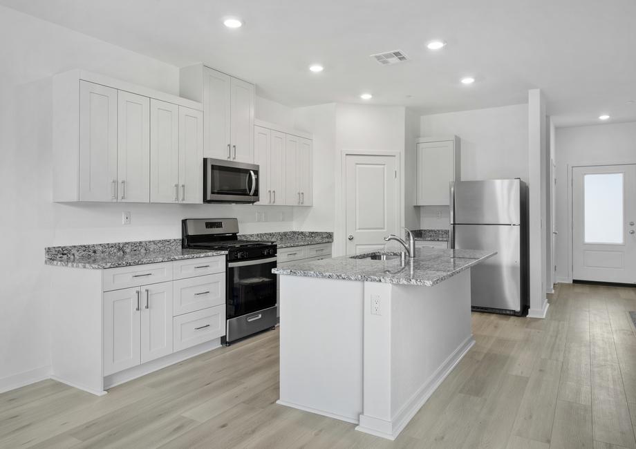 The kitchen has stainless steel appliances and plank flooring.