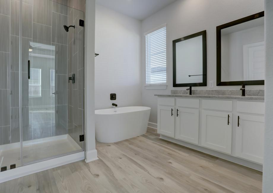 Master bathroom with a soaking tub, walk-in shower, and his and hers sinks.