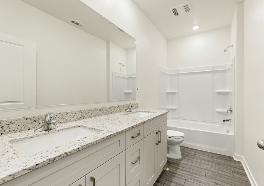 The secondary bathroom has a dual sink vanity and a tub/shower combo.