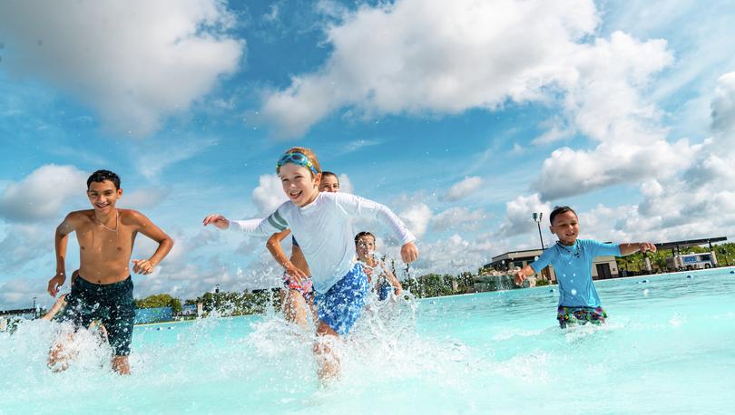 Children run and splash in the water of the lagoon.