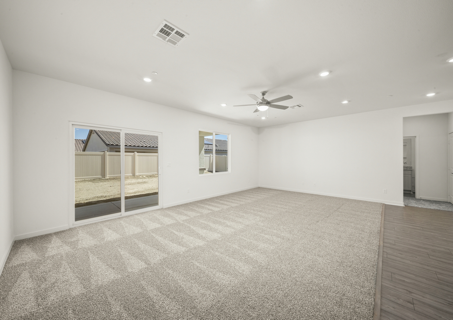 The family room has a ceiling fan and carpet.