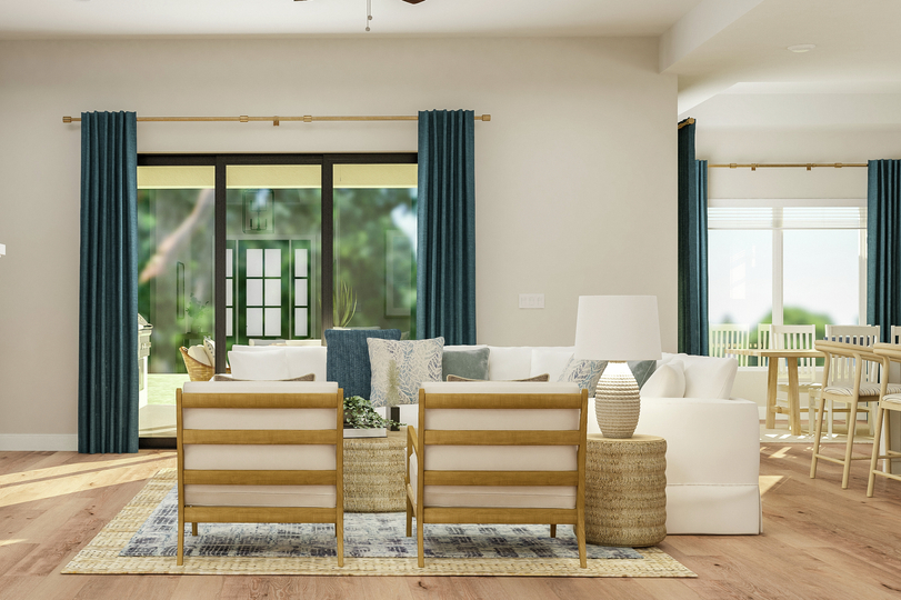 Rendering of the open floor plan living
  area furnished with large sectional couch, two armchairs, coffee table and
  end table. A fireplace and sliding glass door complete the space while the
  dining area is also visible.