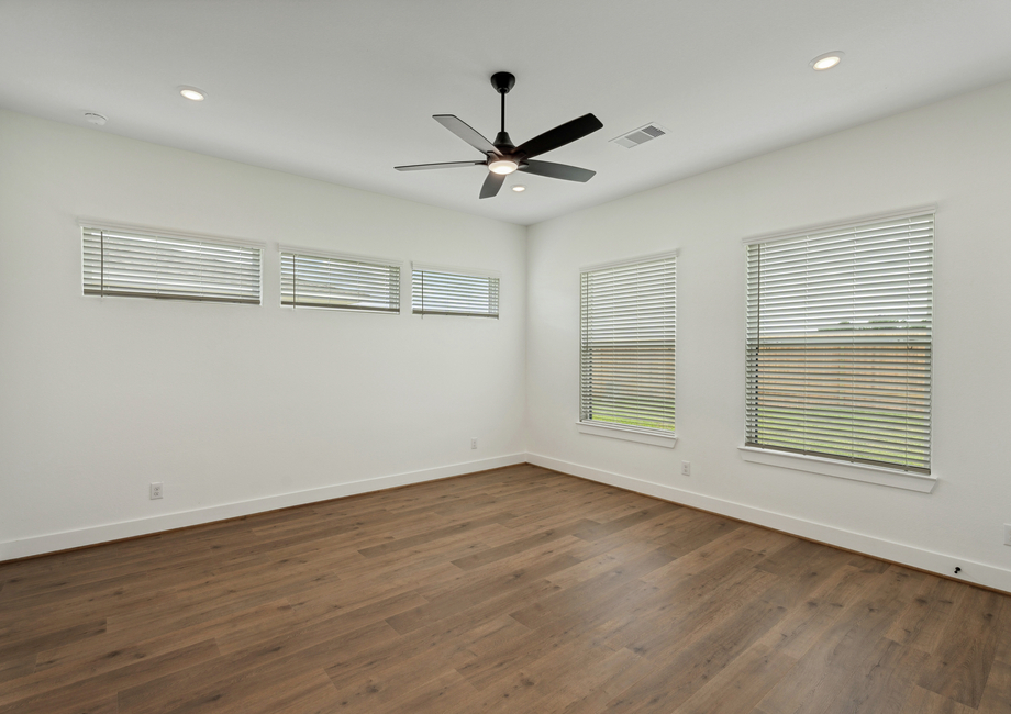Primary bedroom with large windows.