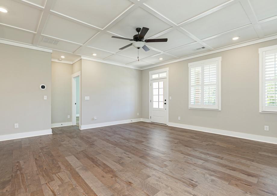 Living room with wood flooring and ceiling fan.