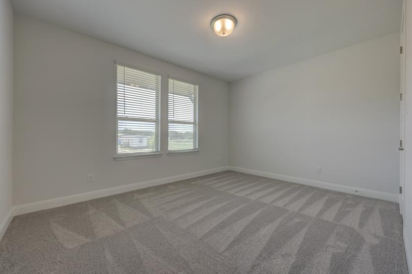 Guest bedroom with two windows and a walk-in closet, providing space for all guests to feel comfortable.