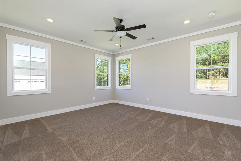 Master bedroom with windows and carpet.