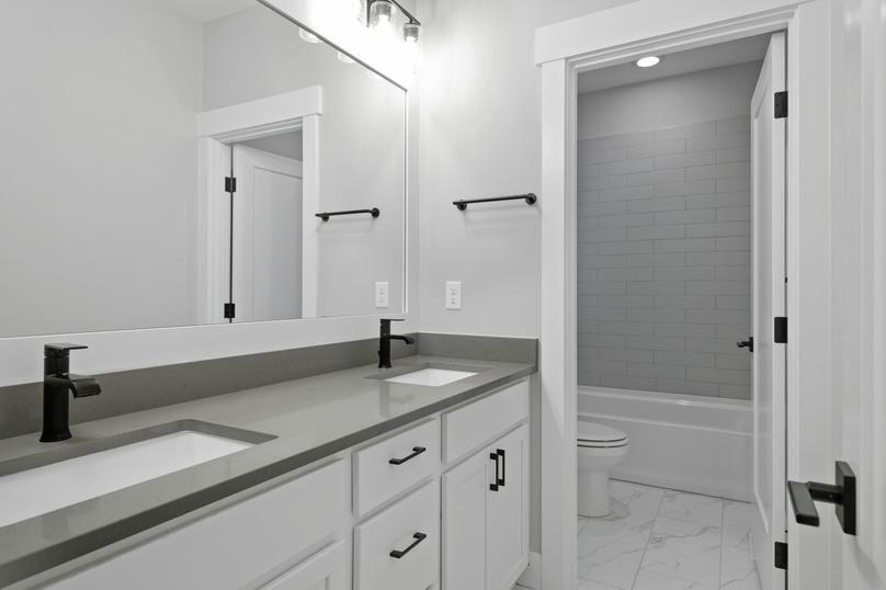 The secondary bathroom showcases a large dual sink vanity.