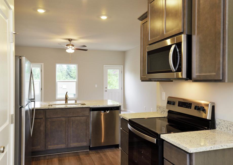 The kitchen has stainless steel appliances and plank flooring. 