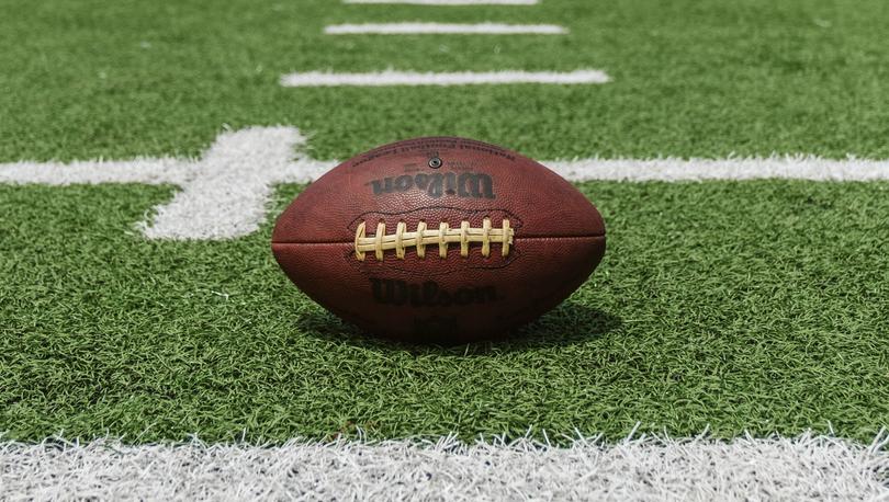 Football sitting on a football field.