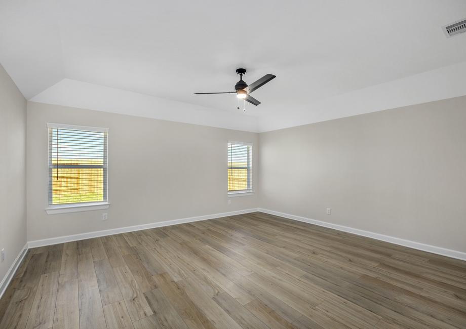 Master bedroom with plank flooring and a ceiling fan