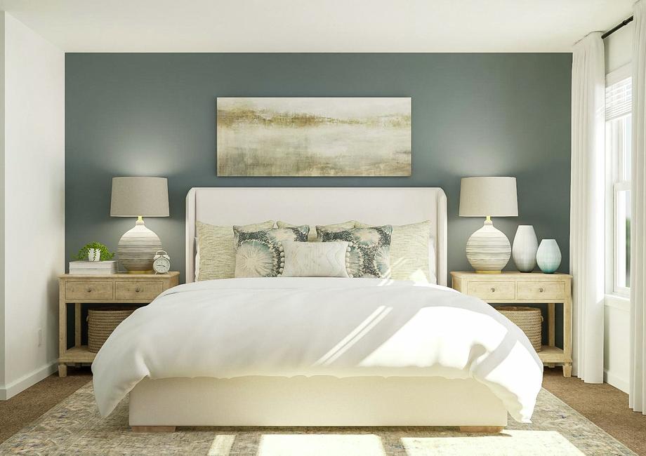 Rendering of the spacious master bedroom
  in the William, which has a large bed flanked by two nightstands against a
  blue-gray accent wall. On the adjacent wall are two windows with white
  curtains.