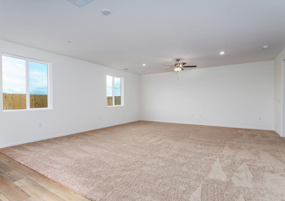 The family room is spacious and has a ceiling fan.