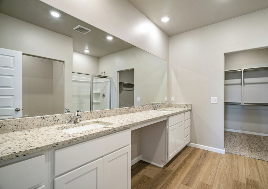 The master bathroom features a glass-enclosed shower, walk-in closet, and built-in vanity space.