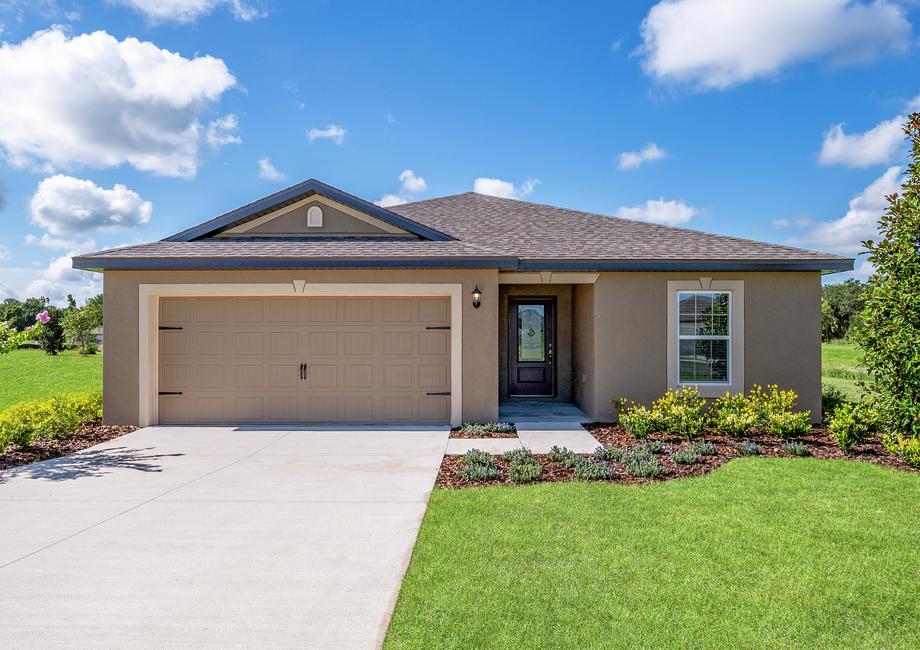 A gorgeous front yard with landscaping and a long driveway.