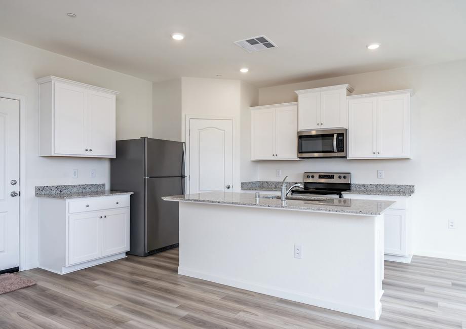 The kitchen has stainless steel appliances and plank flooring.