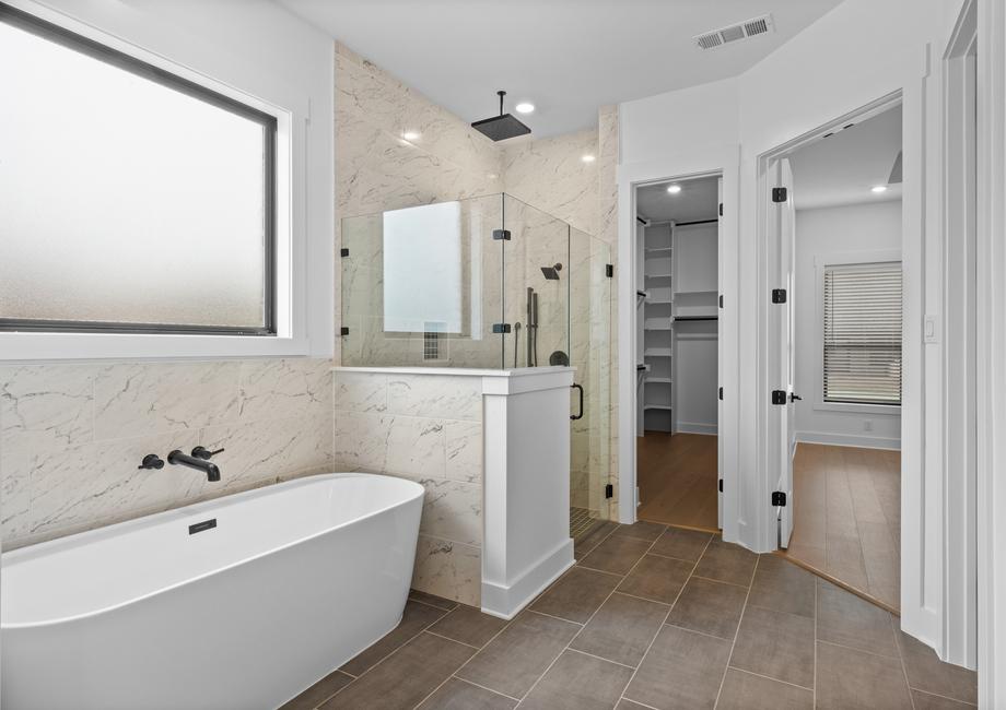 The gorgeous master bathroom has a large glass, walk-in shower and tub.