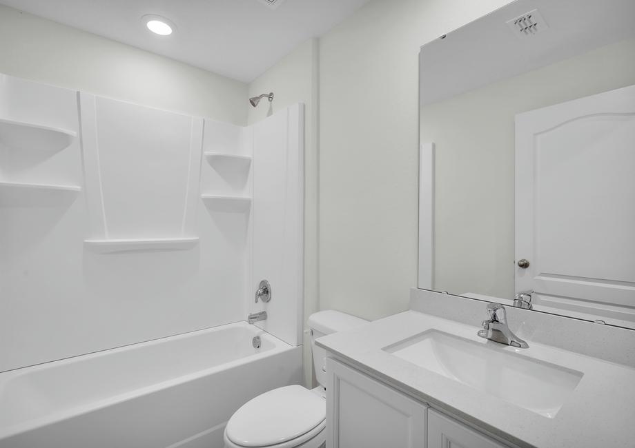 The spare bathroom has a tub and a large vanity