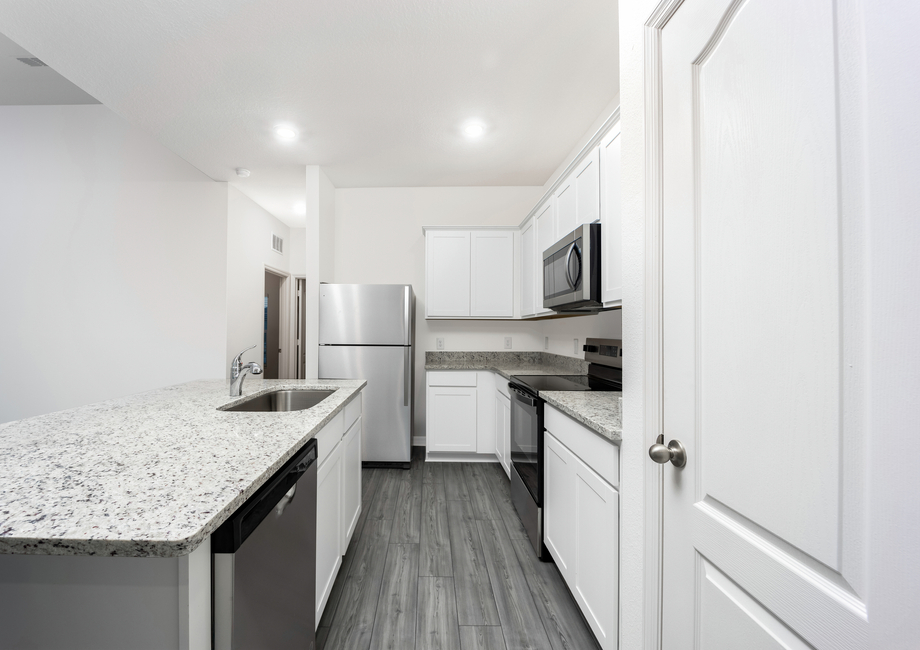 Stainless-steel appliances and granite countertops fill the kitchen