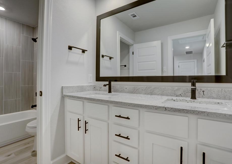 Secondary bathroom with two sinks and lots of cabinet space.