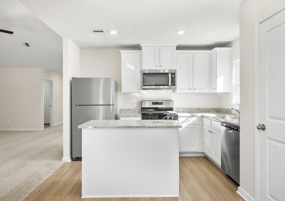 Grey granite countertops and white cabinets fill the kitchen.