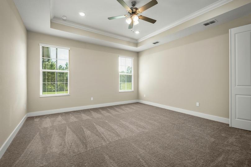 Master bedroom with carpet, windows and a ceiling fan.