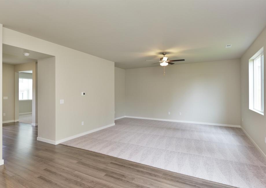 The family room is spacious and has a ceiling fan.