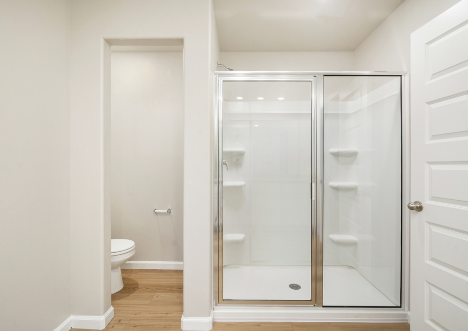 The master bathroom has a beautiful glass-enclosed shower.