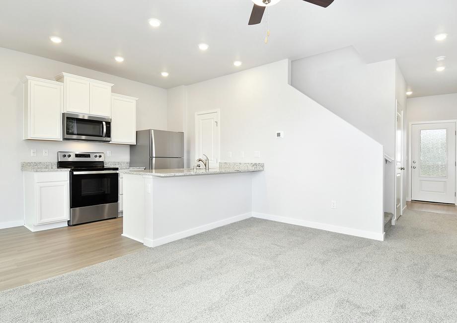 The kitchen has white cabinets and stainless steel appliances.