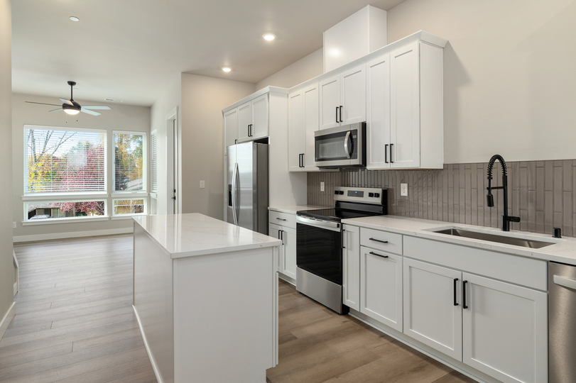 Kitchen with stainless appliances and a moder tile backsplash.