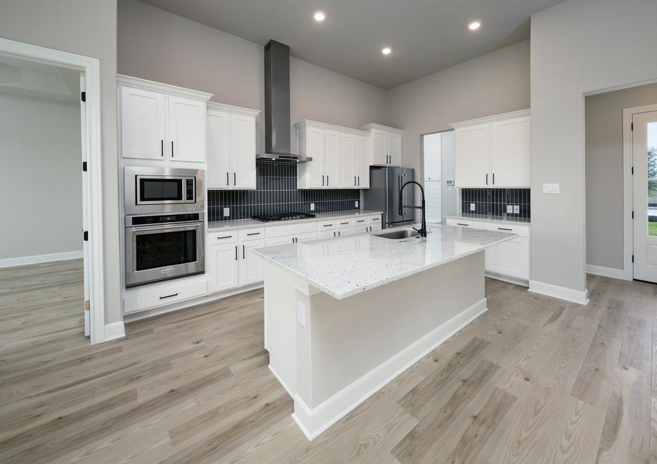 Kitchen with granite island and white cabinets.