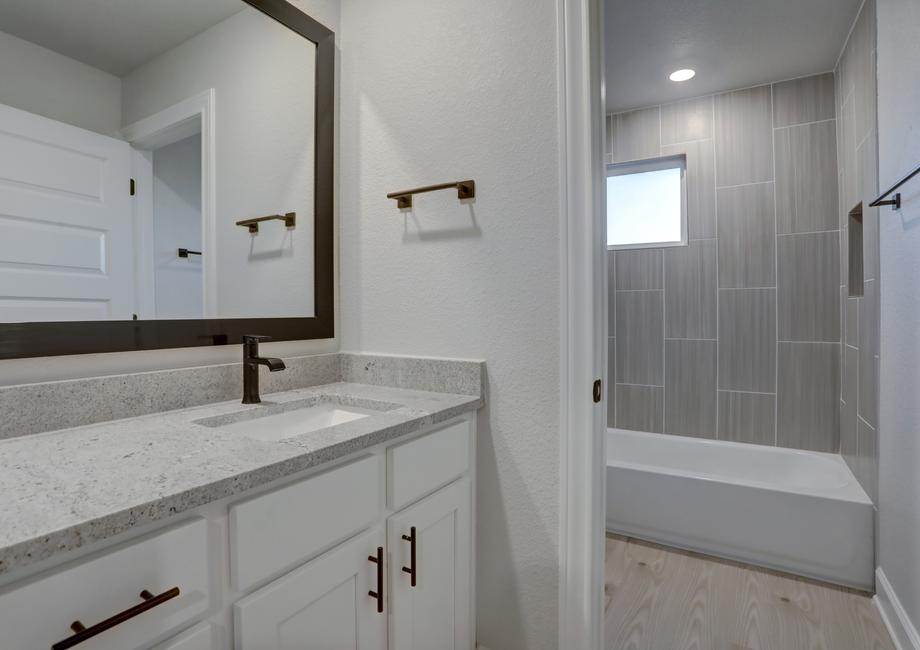 Secondary bathroom with a private restroom and dual shower and tub.