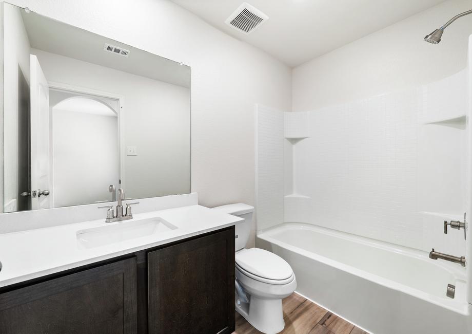 The secondary bathroom of the Sabine has plenty of counterspace and a shower-tub combo.