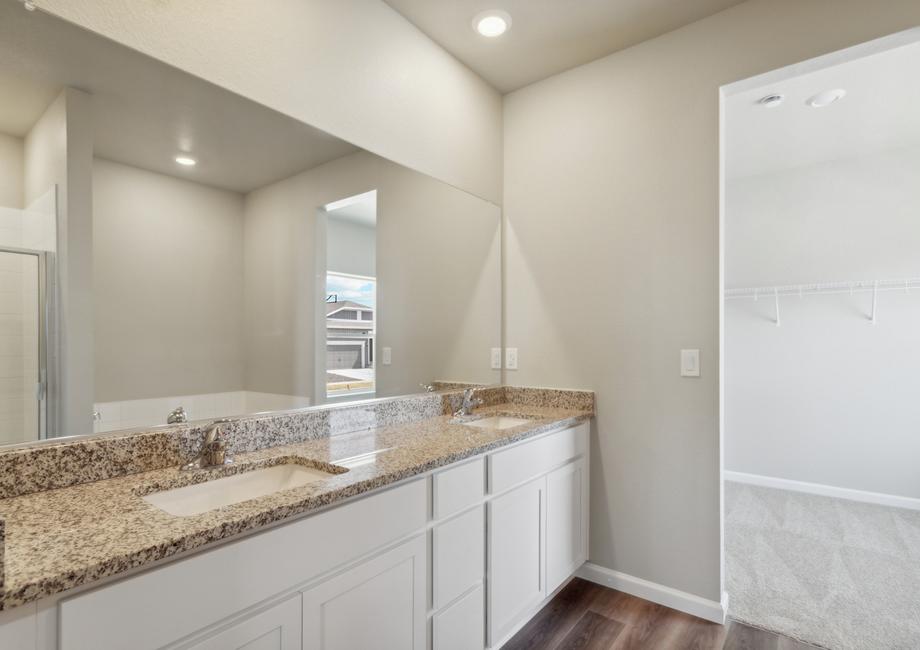 The master bathroom has a large dual sink vanity with a soaking tub and step in shower.