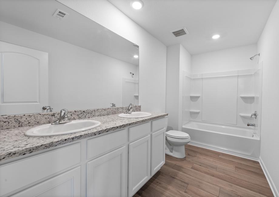 The secondary bathroom features two sinks and a dual shower and tub.
