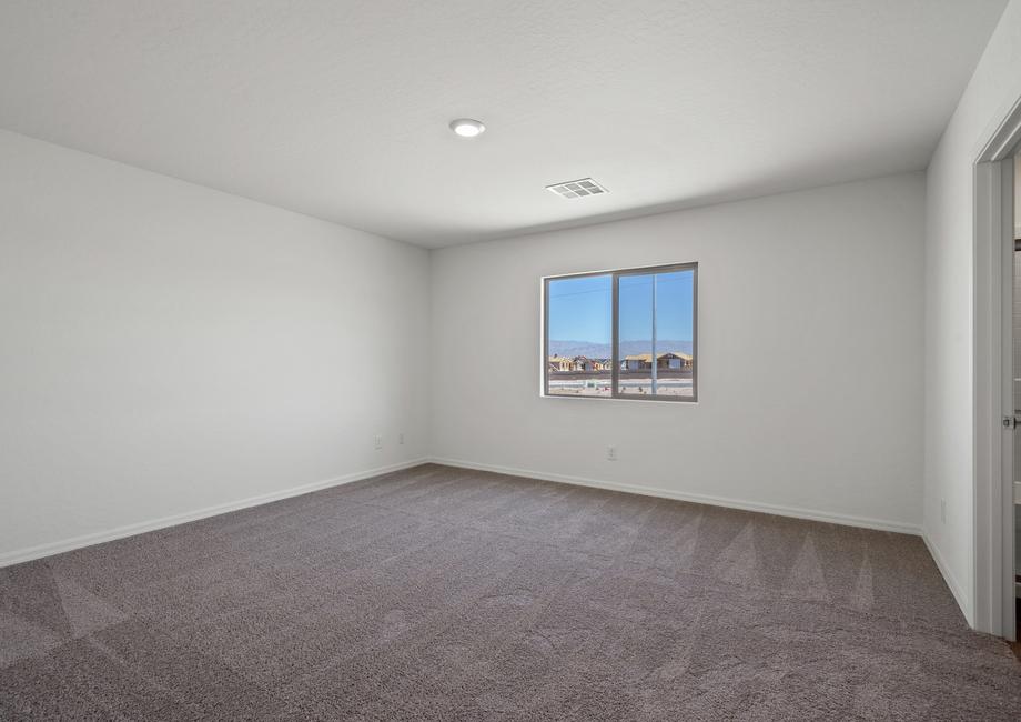 The master bedroom has a large window and carpet.