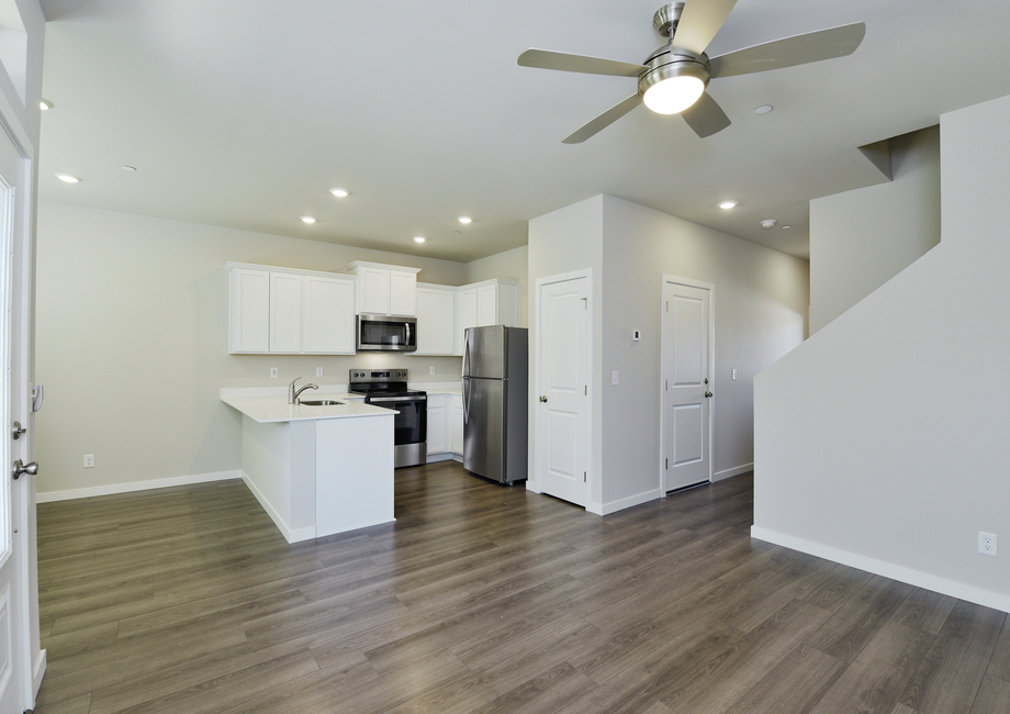 The kitchen has stainless steel appliances and plank flooring.