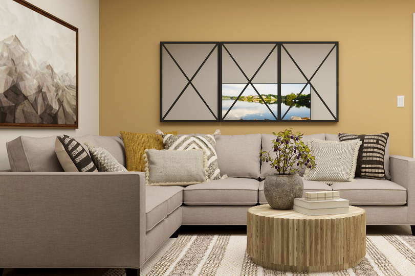 Rendering of a
  loft furnished with a grey sectional and a round coffee tables.