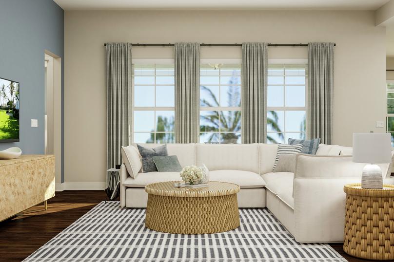 Rendering of living room showing a beige
  media cabinet and tv on left, a white sectional couch and coffee table in
  front of large windows center, and the corner of the dining room on right
  with dark wood look flooring throughout.